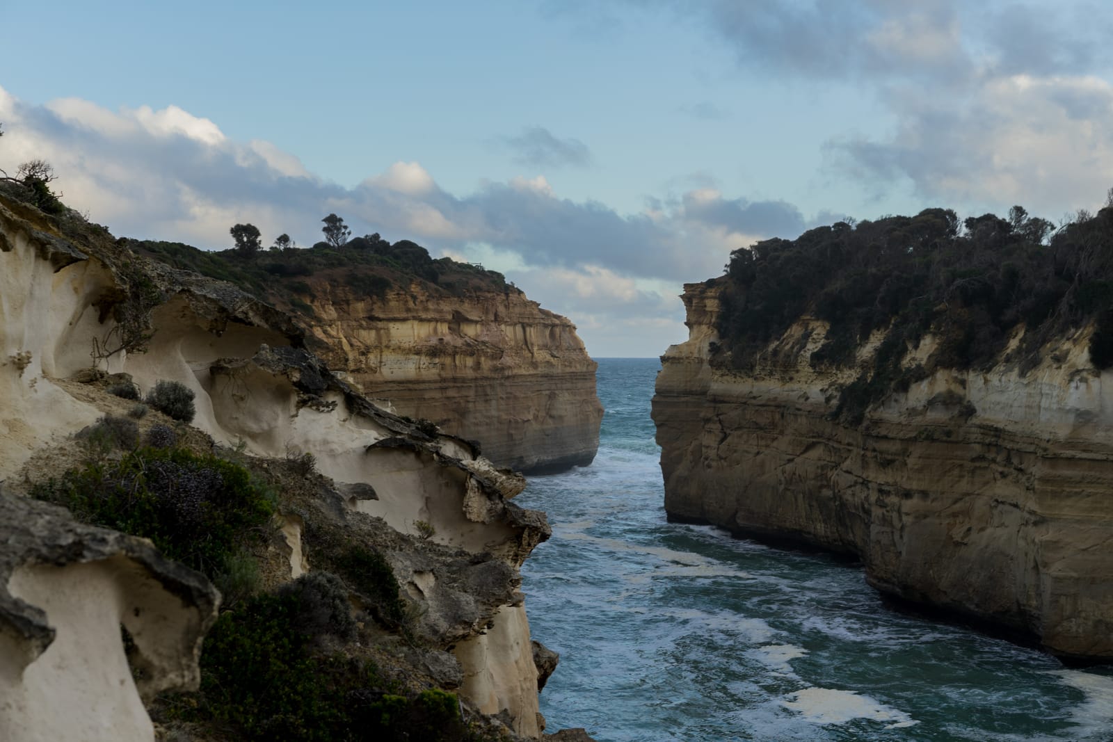 A narrow inlet of turquoise water between two sandstone headlands