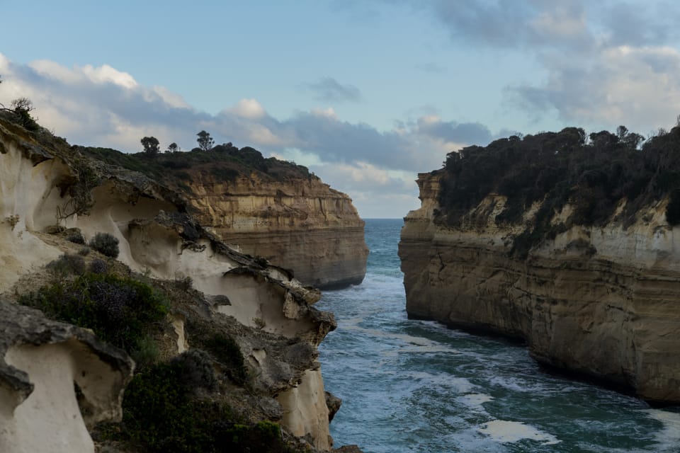 A narrow inlet of turquoise water between two sandstone headlands