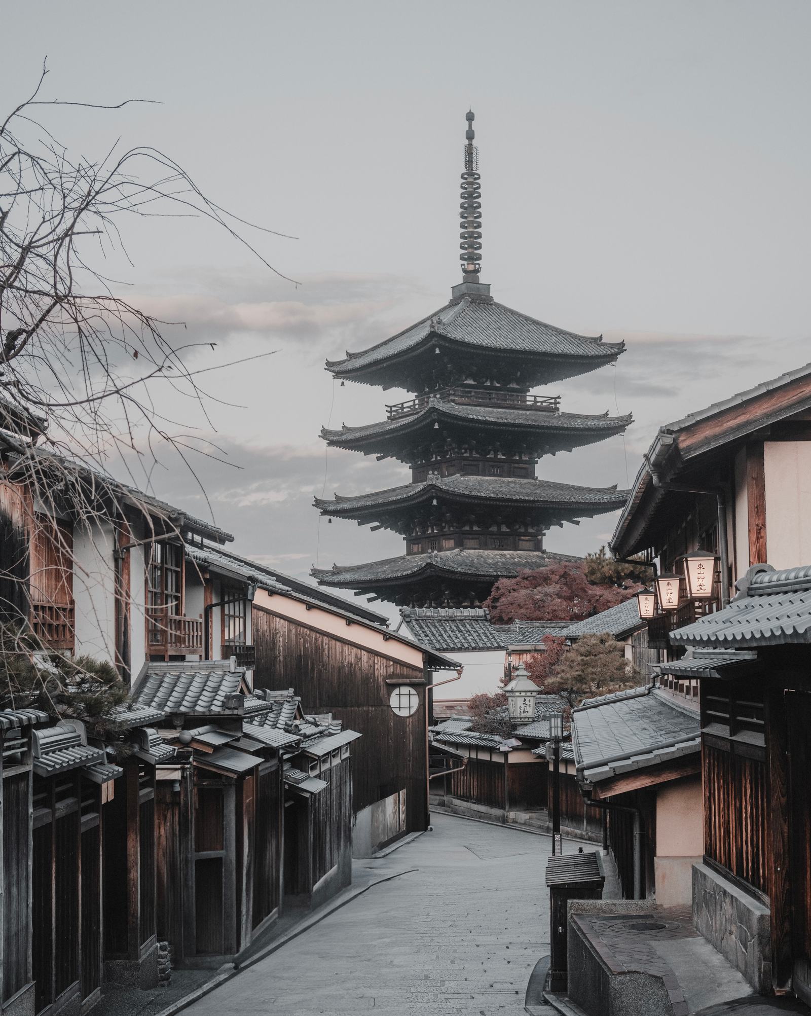 The five-storey Yasaka Pagoda rising above a quiet street of old wooden houses and lanterns in Kyoto